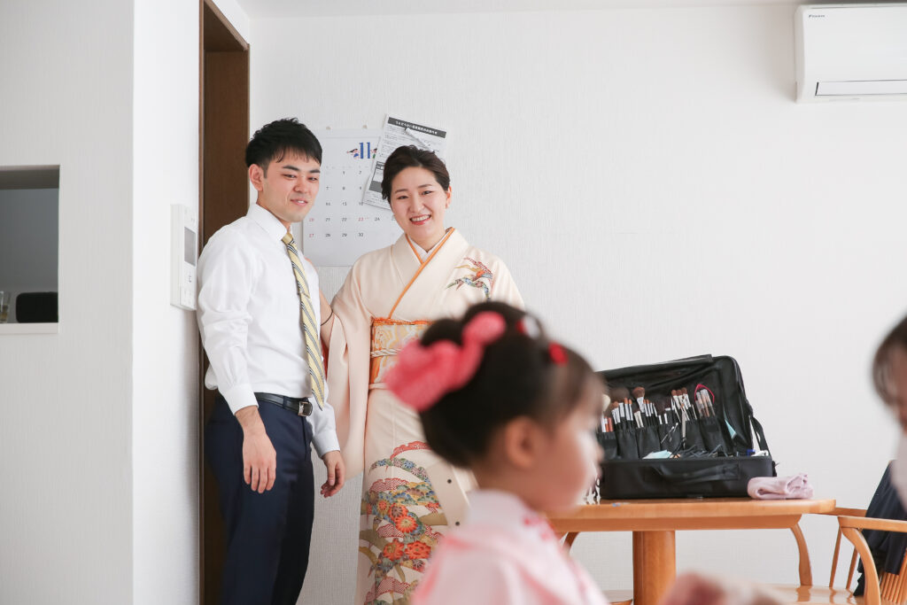 自宅お支度風景お子様の支度の様子を微笑ましく見つめる両親